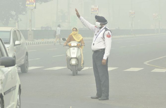 Patiala: A policeman wears a mask as he manages traffic amid heavy smog, in Patiala, Sunday, Nov. 3, 2019. (PTI Photo) 