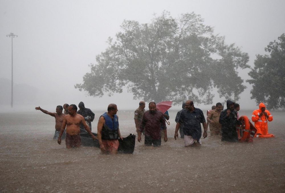 Members of a rescue team wade through a water-logged area during heavy rains on the outskirts of Kochi in Kerala, August 8, 2019. REUTERS/Sivaram V