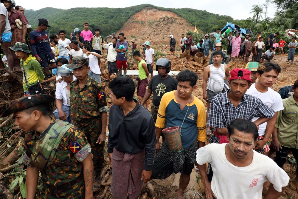 Residents and survivors stand at the site of a landslide in Mottama, Mon state, Myanmar, August 10, 2019. REUTERS/Ann Wang