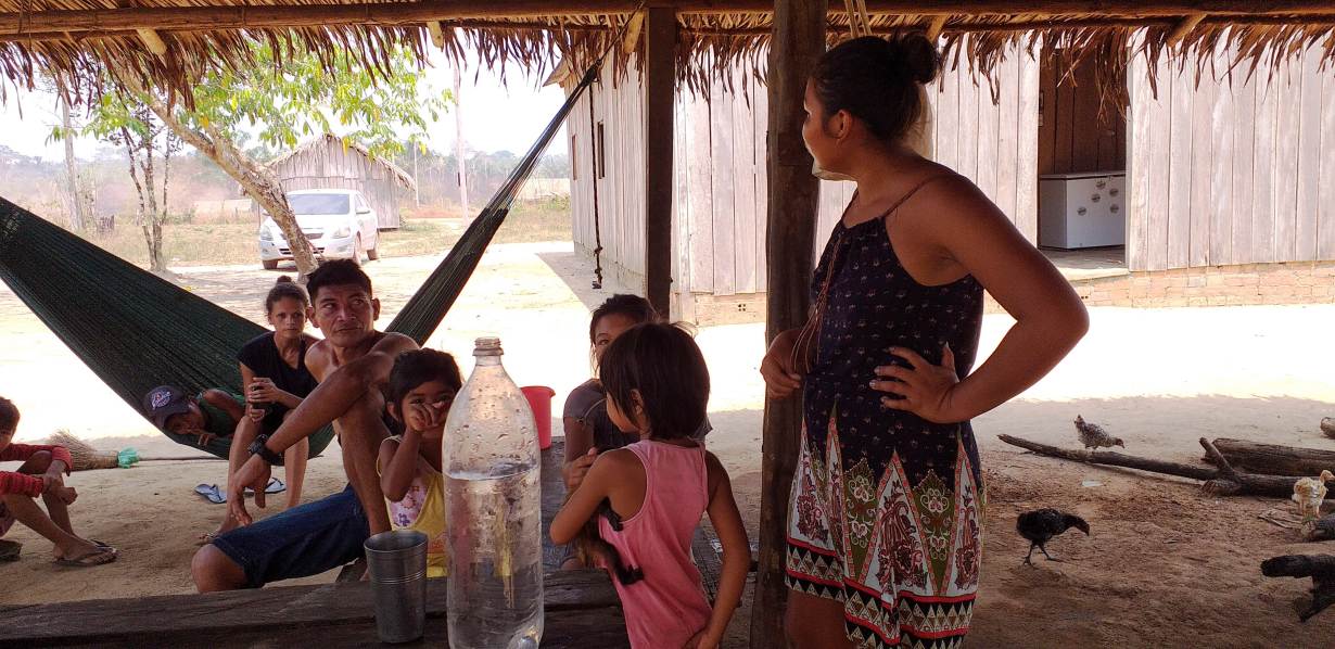 Members of the Tenharim indigenous community gather under a thatched roof in the state of Amazonas, Brazil, Sept. 1, 2019. Thomson Reuters Foundation/Fabio Teixeira