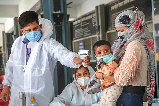 Migrants being screened by medics as they arrive to board a special train for Udhampur in Jammu and Kashmir, during covid-19 lockdown, at Habibganj Railway Station in Bhopal, Monday, May 18, 2020. (PTI Photo)