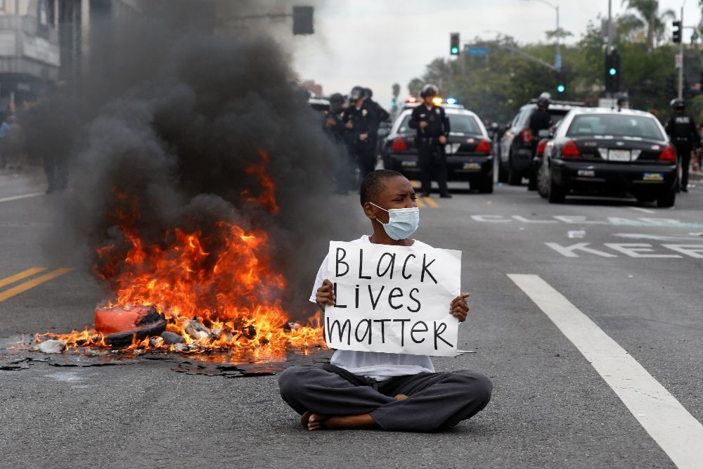 A demonstrator holds a placard during a protest against the death in Minneapolis police custody of George Floyd, in Los Angeles, California, U.S., May 30, 2020. REUTERS/Patrick T. Fallon