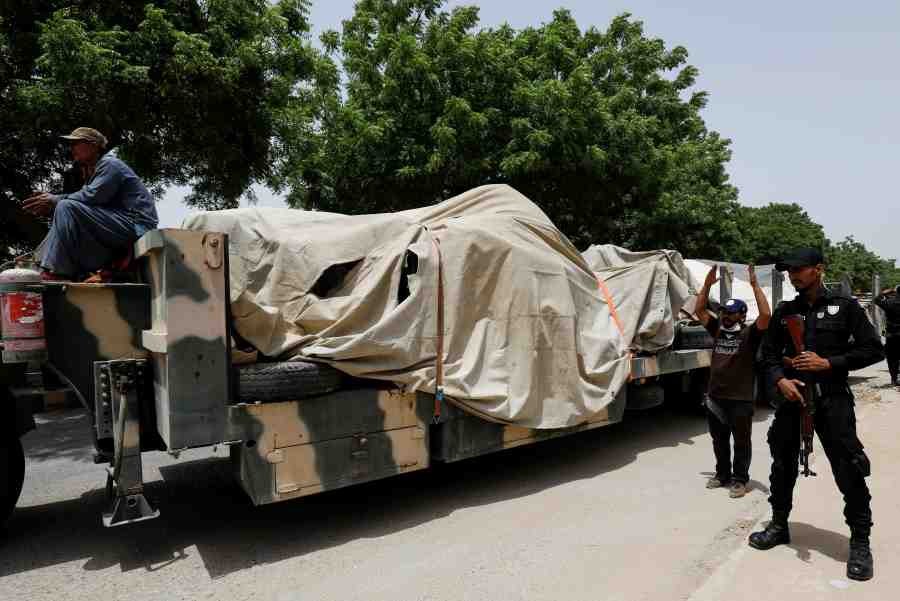 A police officer stands guard beside a truck loaded with the wreckage of the crashed Pakistan International Airlines' PK8303 plane, in Karachi, Pakistan. (Reuters Photo)