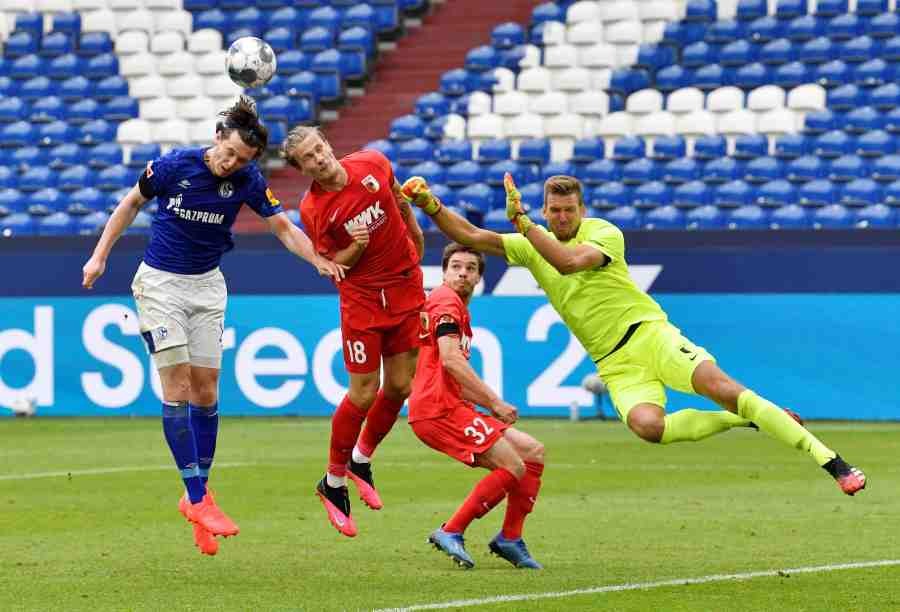 Schalke 04's Michael Gregoritsch in action with FC Augsburg's Tin Jedvaj and Andreas Luthe, as play resumes behind closed doors following the outbreak of COVID-19. (Reuters Photo)