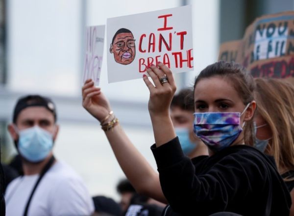 A woman holds a placard as she attends a banned demonstration planned in memory of Adama Traore, a 24-year-old black Frenchman who died in a 2016 police operation which some have linked to the death of George Floyd in the United States, in front of courthouse in Paris, France on June 2, 2020. (REUTERS Photo)