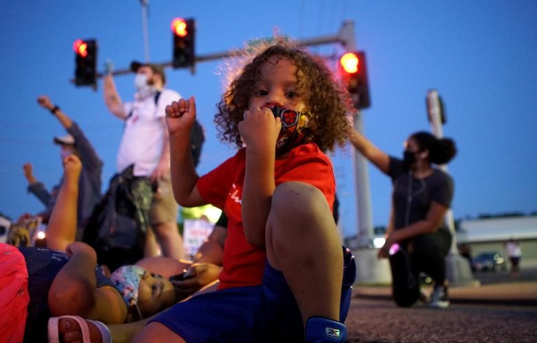 A child raises his fist during a protest against the police brutality of a man hit by a Florissant detective and the death in Minneapolis police custody of George Floyd, in Florissant, Missouri. REUTERS/Lawrence Bryant
