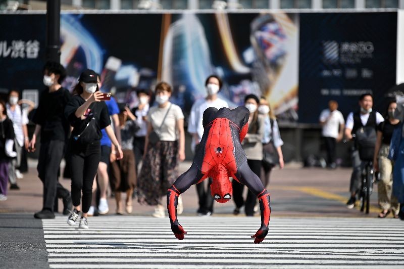 A man wearing a Spiderman costume jumps across Shibuya crossing in Tokyo on June 8, 2020. (Photo by Charly Triballeau/AFP Photo)
