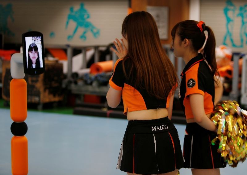 Yomiuri Giants cheerleaders talk to a fan, Futaba Tsuchiya, on a monitor during their game against Hiroshima Toyo Carp, held without spectators due to the spread of the coronavirus disease (COVID-19) at Tokyo Dome in Tokyo, Japan June 23, 2020. REUTERS/Jack Tarrant