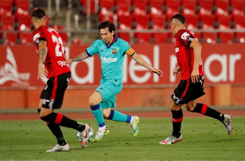Barcelona's Lionel Messi in action with Mallorca's Ante Budimir, as play resumes behind closed doors following the outbreak of the coronavirus disease (COVID-19) REUTERS/Albert Gea