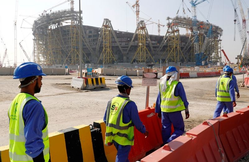 Workers walk towards the construction site of the Lusail stadium which will be build for the upcoming 2022 Fifa soccer World Cup during a stadium tour in Doha, Qatar, December 20, 2019. REUTERS/Kai Pfaffenbach/Files