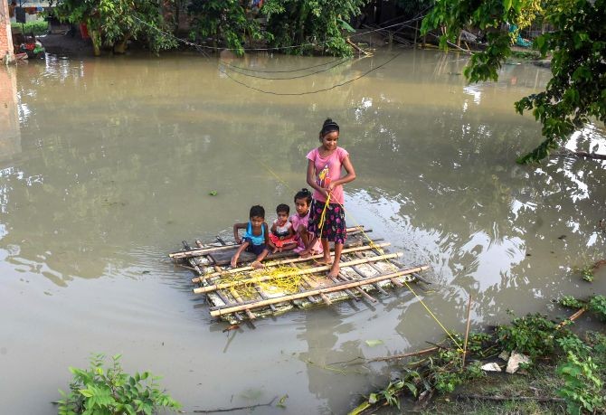 Children use a makeshift boat to cross a flood-affected area of Mayong village in Morigaon District of Assam, Sunday, June 28, 2020. (PTI Photo)