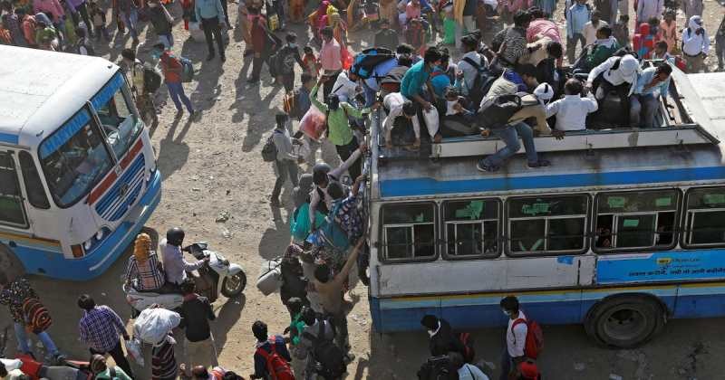 Migrant workers travel on crowded buses as they return to their villages, on the Delhi-Ghaziabad border. | Reuters