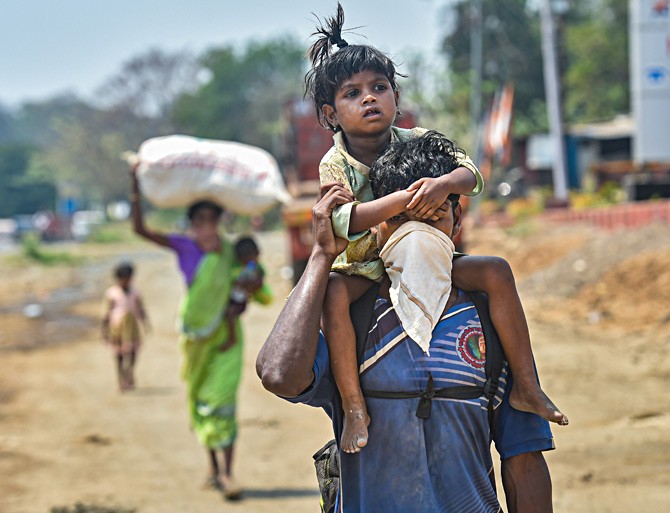 A migrant worker and his family walk to their village in the summer heat along the Mumbai-Ahmedabad highway in Palghar, Maharashtra, following the coronavirus-provoked lockdown.  PTI File Photo