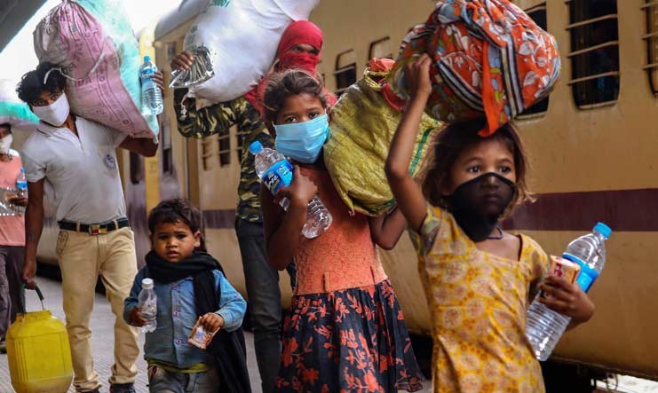 Migrant children along with their families arrive to board a special train to Uttar Pradesh, during the ongoing COVID-19 nationwide lockdown, in Ajmer | PTI