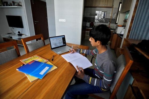 A student makes notes as he attends an online class at his home after Gujarat government ordered the closure of schools and colleges across the state amid coronavirus disease (COVID-19) fears, in Ahmedabad on March 17, 2020. (REUTERS File Photo)