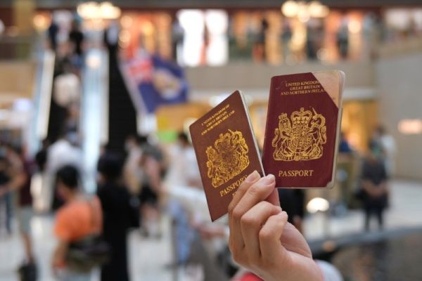 A pro-democracy demonstrator raises his British National Overseas (BNO) passports during a protest against new national security legislation in Hong Kong, China on June 1, 2020. (REUTERS Photo)