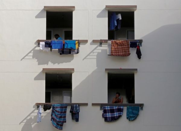 Migrant workers look out of windows in a dormitory, amid the coronavirus disease (COVID-19) outbreak in Singapore on May 15, 2020. (REUTERS File Photo)