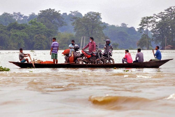Villagers cross a flooded area on a boat, following heavy monsoon rain, at a village in Morigaon district, Sunday, June 28, 2020. (PTI Photo)
