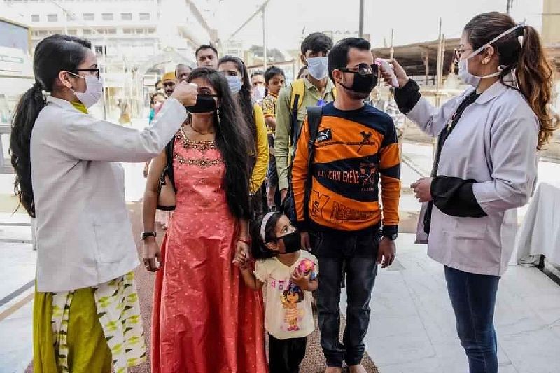 Health workers (L and R) wearing facemasks check the body temperature of devotees amid concerns over the spread of the COVID-19 novel coronavirus, at the entrance of the Durgiana Temple in Amritsar. (Photo: AFP)