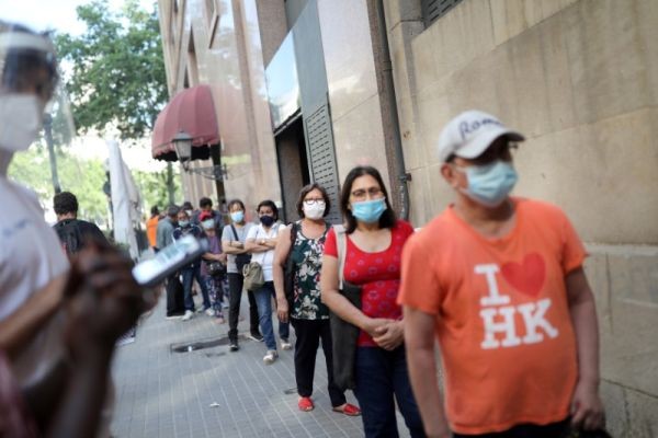 People queue as they wait for free food packages amid economic hardship outside parish church of Santa Anna, amid the coronavirus disease (COVID-19) outbreak, in Barcelona, Spain on June 2, 2020. (REUTERS Photo)