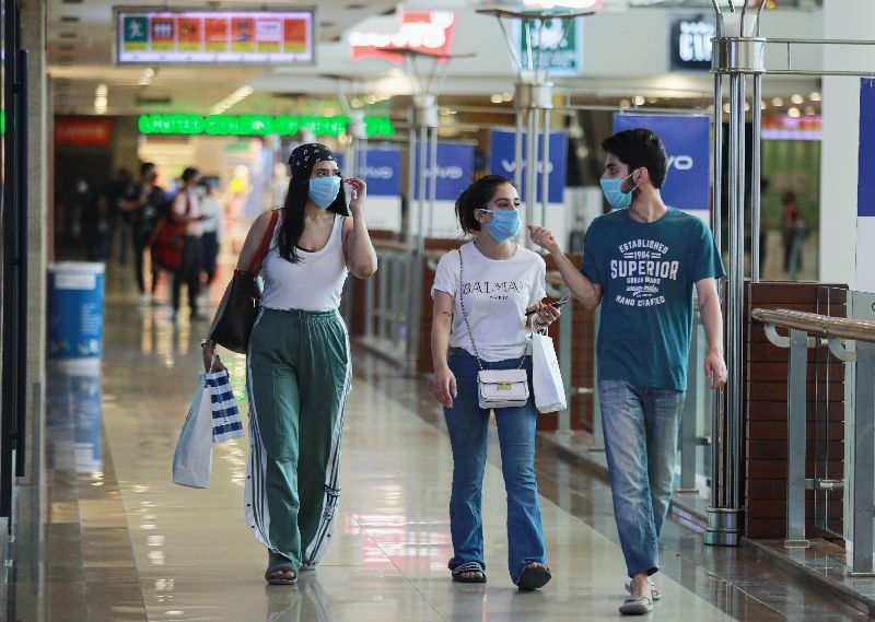 People wearing masks walk with shopping bags inside a mall as India eases lockdown restrictions that were imposed to slow the spread of the coronavirus disease (COVID-19), in New Delhi, June 8, 2020. REUTERS/Anushree Fadnavis