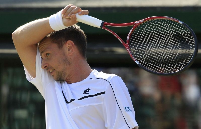 Robin Soderling of Sweden wipes his forehead during his match against Bernard Tomic of Australia at the Wimbledon tennis championships in London June 25, 2011. REUTERS/Suzanne Plunkett/File photo