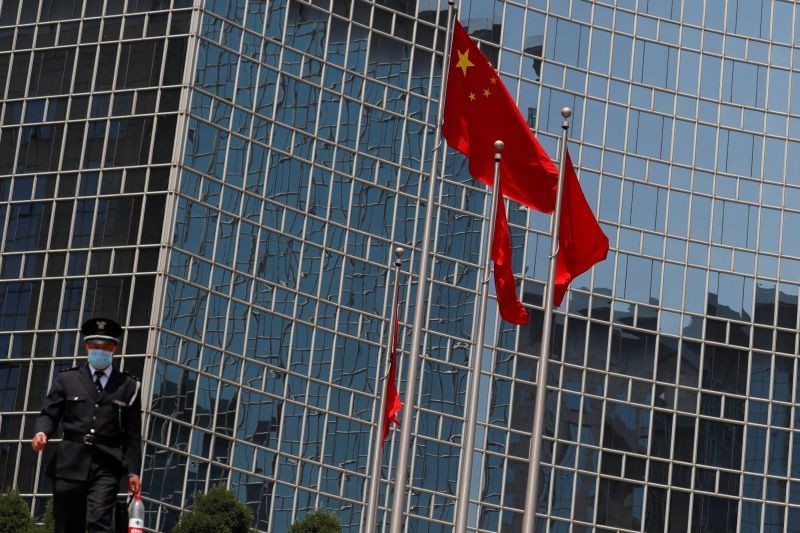 A security guard walks near the Chinese national flag in Beijing, China on April 29, 2020. (REUTERS File Photo)