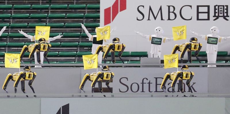 SoftBank Corp's humanoid robots Pepper and Boston Dynamics' robots SPOT in baseball uniforms cheer the team next to empty spectator seats at a baseball game between SoftBank Hawks and Tohoku Rakuten Golden Eagles as Nippon Professional Baseball league behind closed doors due to the spread of the coronavirus disease (COVID-19) in Fukuoka, Japan