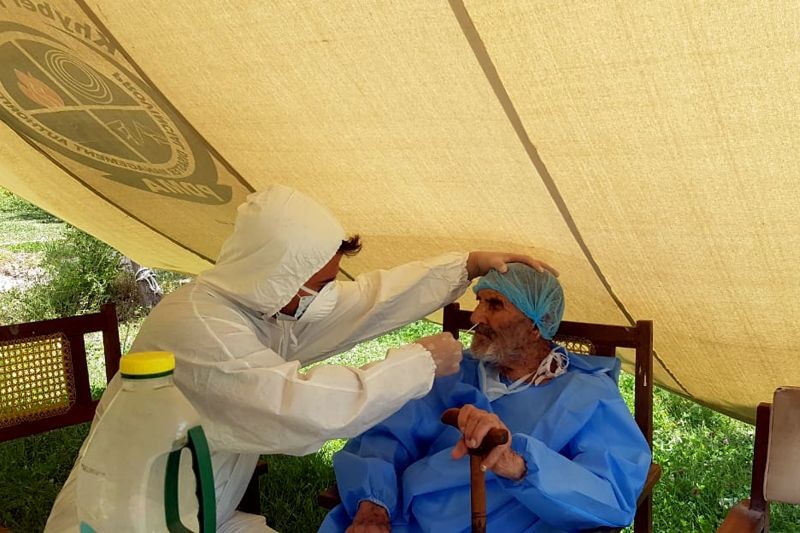 A paramedic wearing protective gear takes a nasal swab of 103 year-old Abdul Alim, to be tested for the coronavirus disease (COVID-19), at the Aga Khan Health Services Emergency Response Centre in Booni, Chitral, Pakistan in this undated photograph provided to Reuters. (REUTERS Photo)