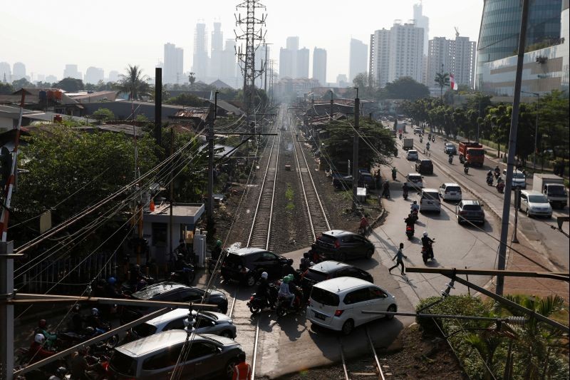 A man crosses a road during morning rush hours after the government eased restrictions following the coronavirus disease (COVID-19) outbreak, near a densely populated residential area in Jakarta, Indonesia on July 8, 2020. (REUTERS Photo)