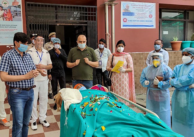 Medics applaud a 98-yr old woman as she is discharged from the Government Medical College Hospital after recovering from COVID-19, in Rjouri, J-K, on Saturday. Photograph: PTI Photo