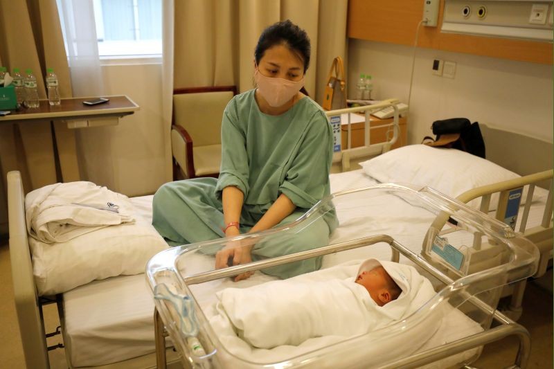 Local bank auditor Nguyen Huyen Trang, wearing a protective mask, looks at her newborn son Phuc An at Vinmec hospital during the coronavirus disease (COVID-19) outbreak in Hanoi, Vietnam on April 4, 2020. (REUTERS File Photo)