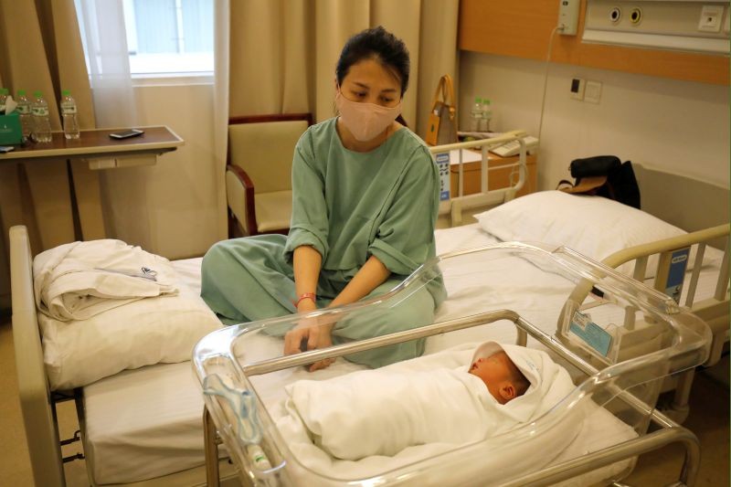 Local bank auditor Nguyen Huyen Trang, wearing a protective mask, looks at her newborn son Phuc An at Vinmec hospital during the coronavirus disease (COVID-19) outbreak in Hanoi, Vietnam on April 4, 2020. (REUTERS File Photo)