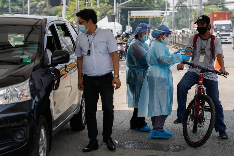 Healthcare workers take blood samples from a bike rider at a coronavirus disease (COVID-19) drive-thru testing center in Manila, Philippines on July 15, 2020. (REUTERS File Photo)