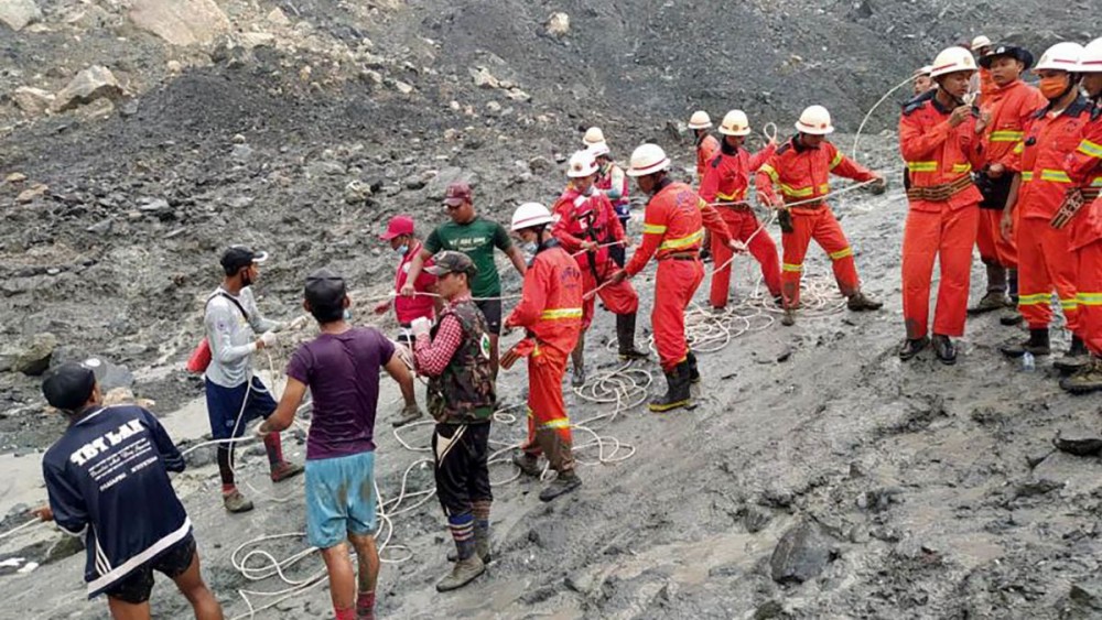 A handout photo made available by the Myanmar Fire Services Department shows rescue workers at a jade mining site in Hpakant, Myanmar, on July 2.