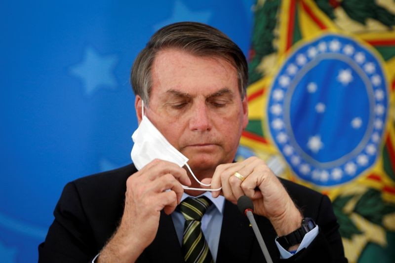 Brazil's President Jair Bolsonaro adjusts his protective face mask during a press statement to announce federal judiciary measures to curb the spread of the coronavirus disease (COVID-19) in Brasilia, Brazil on March 18, 2020. (REUTERS File Photo)