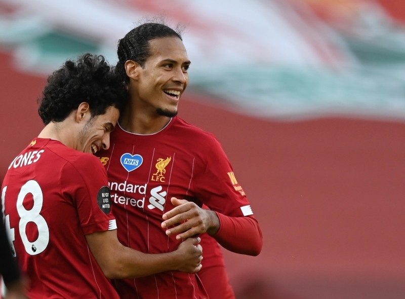 Liverpool's Curtis Jones celebrates with Virgil van Dijk after the match, as play resumes behind closed doors following the outbreak of the coronavirus disease (COVID-19) Shaun Botterill / Pool via REUTERS