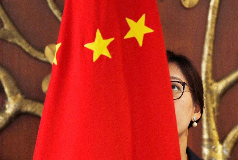 A Chinese official adjusts a Chinese flag before the start of a meeting between Foreign Minister Wang Yi and Indian Foreign Minister Sushma Swaraj in New Delhi, India, December 21, 2018. REUTERS/Adnan Abidi