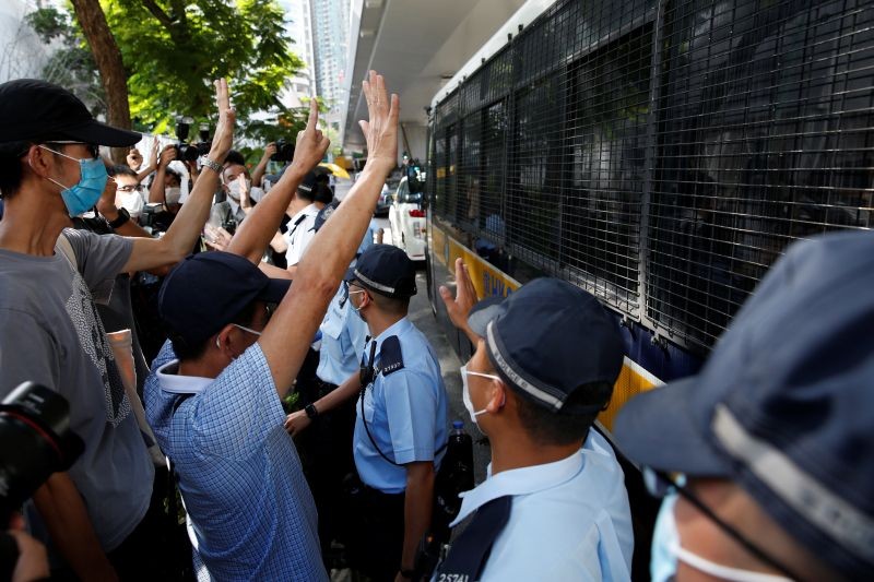 Supporters of Tong Ying-kit, the first person charged under the new national security law, greet a prison van outside West Kowloon Magistrates' Courts in Hong Kong, China on July 6. (REUTERS Photo)