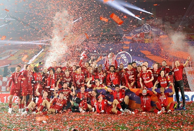 Liverpool players and staff pose with the trophy after winning the Premier League Pool via REUTERS/Phil Noble