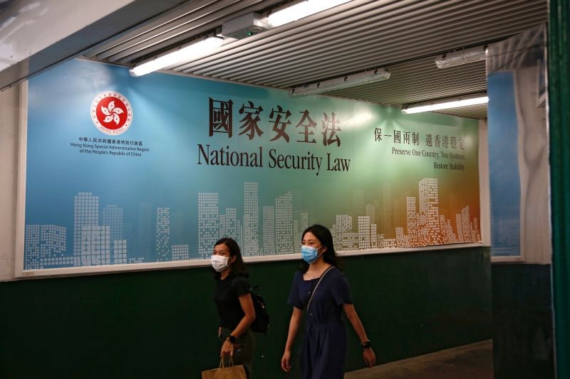 Women walk past a government-sponsored advertisement promoting the new national security law as a meeting on national security legislation takes place in in Hong Kong, China on June 29, 2020. (REUTERS File Photo)