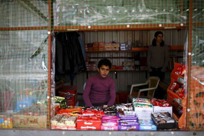 Syrian refugee Resad Bekur, 18, poses in a shop where he works in Yayladagi refugee camp in Hatay province, near the Turkish-Syrian border, Turkey on December 16, 2015. Syria's conflict has left hundreds of thousands dead, pushed millions more into exile, and had a profound effect on children who lost their homes or got caught up in the bloodletting. The drawings of young refugees living in Turkey show their memories of home and hopes for its future. The pictures also point to the mental scars borne by 2.3 million Syrian refugees living in Turkey, more than half of them children. (REUTERS File Photo)