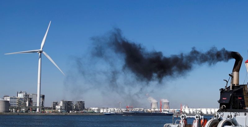 Smoke rises from a pilot boat near a wind turbine and the cooling towers of the Doel nuclear plant in the port of Antwerp on Belgium April 22, 2020. (REUTERS File Photo)