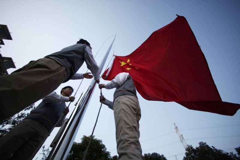 Young Pioneers raise the Chinese national flag during the weekly flag-raising ceremony at the East Experimental School in Shanghai on November 5, 2012. (REUTERS File Photo)