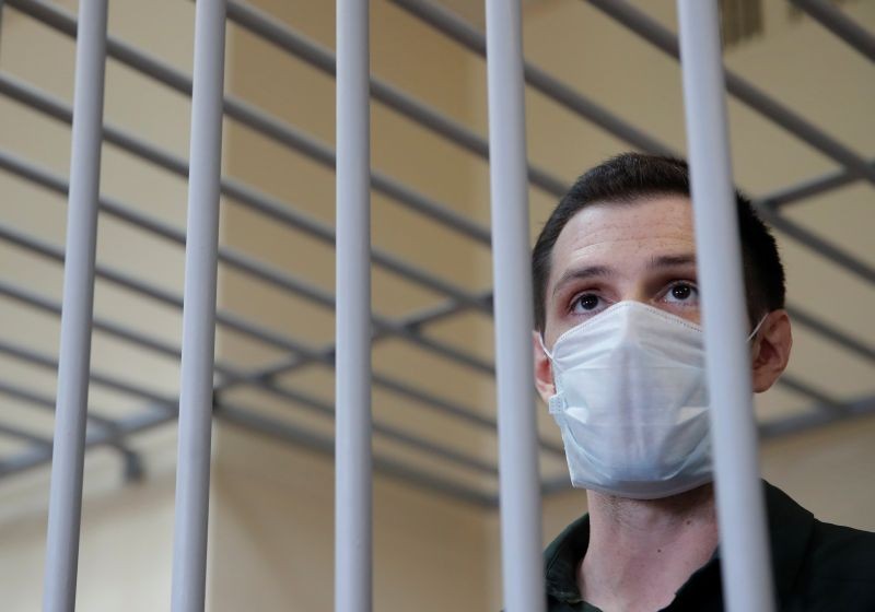 Former U.S. Marine Trevor Reed, who was detained in 2019 and accused of assaulting police officers, stands inside a defendants' cage during a court hearing in Moscow, Russia on July 30, 2020. (REUTERS Photo)