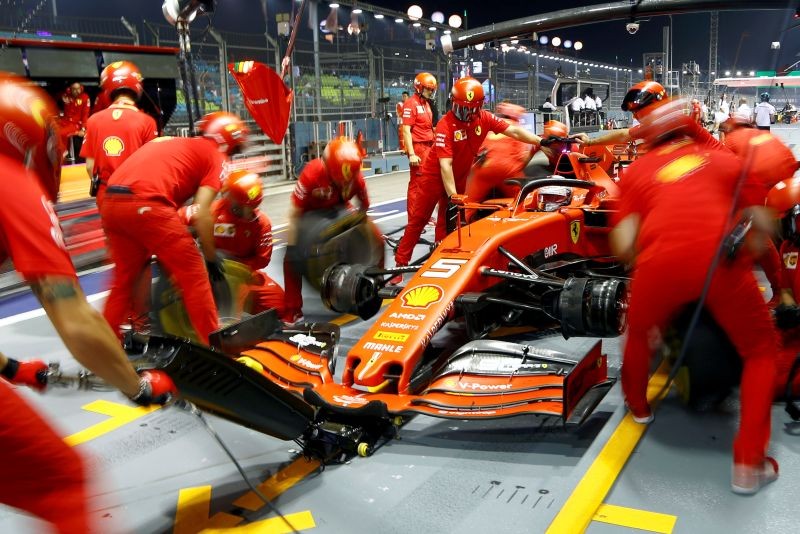 Ferrari's Sebastian Vettel and mechanics during practice REUTERS/Feline Lim/File Photo