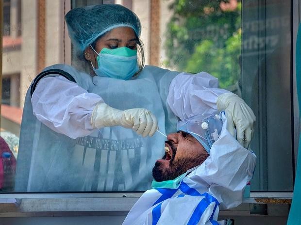 A medic collects samples from a man for COVID-19 swab tests at Civil Hospital, during the ongoing nationwide lockdown, in Amritsar. Photo: PTI