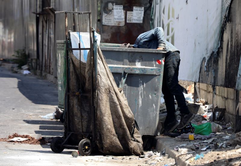 A man searches through a garbage bin in Beirut, Lebanon on June 30, 2020. (REUTERS File Photo)