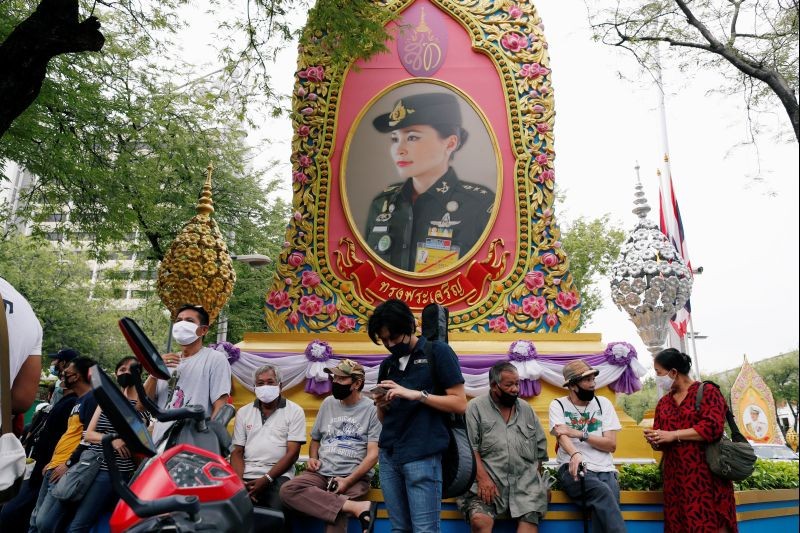 Pro-democracy activists wearing protective masks sit under a portrait of Thai Queen Suthida during a protest demanding the resignation of Thailand's Prime Minister Prayut Chan-o-cha in front of Royal Thai Army headquarters, in Bangkok, Thailand on July 20. (REUTERS Photo)