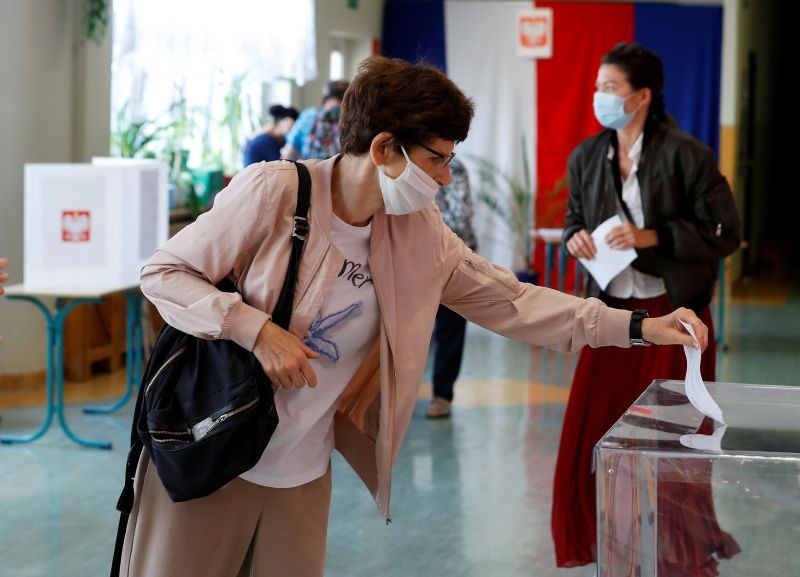 A voter wearing a protective mask casts a ballot during the second round of presidential election at a polling station in Warsaw, Poland on July 12, 2020. (REUTERS Photo)